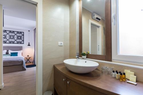 ザダルにあるThe Well Luxury Roomsのバスルーム(白いシンク付)、ベッドルーム1室