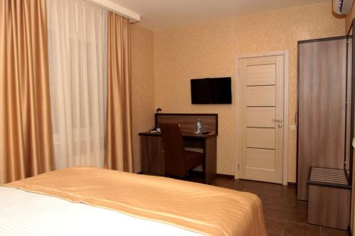 a hotel room with a bed and a desk and a television at Hotel Lubenska Sloboda in Vilʼshanka
