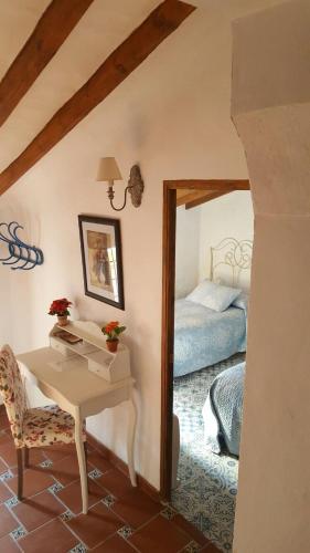 a bedroom with a bed and a table and a desk at Casa La Arracada in Villena
