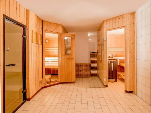 a large room with wooden walls and a bathroom at Appartements Kolberhof in Alpbach