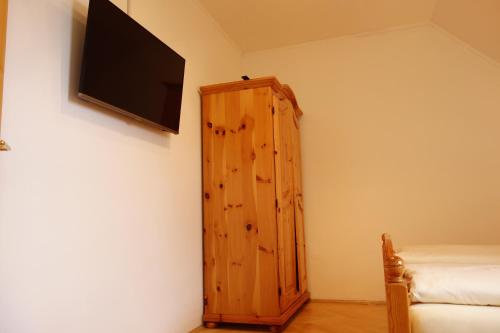a room with a wooden cabinet and a flat screen tv at Weingut Primus Südsteiermark in Spielfeld