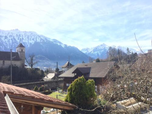 einen Blick auf ein Haus mit Bergen im Hintergrund in der Unterkunft Royal Swiss Apartments in Ringgenberg