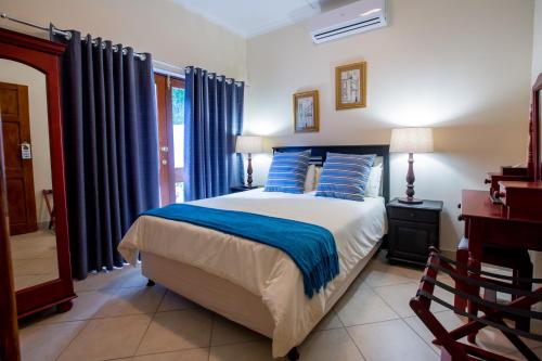 a bedroom with a large bed with blue pillows at Turtle Bay Lodge in St Lucia