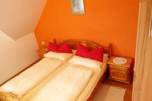 a small bedroom with two beds with red pillows at Weingut Primus Südsteiermark in Spielfeld