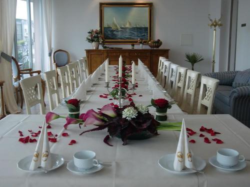 a long table with flowers and candles on it at Hotel Am Yachthafen in Waren