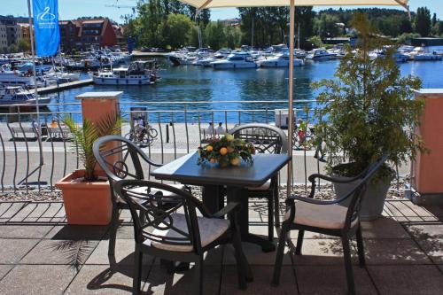 a table and chairs with a table and boats in the water at Hotel Am Yachthafen in Waren