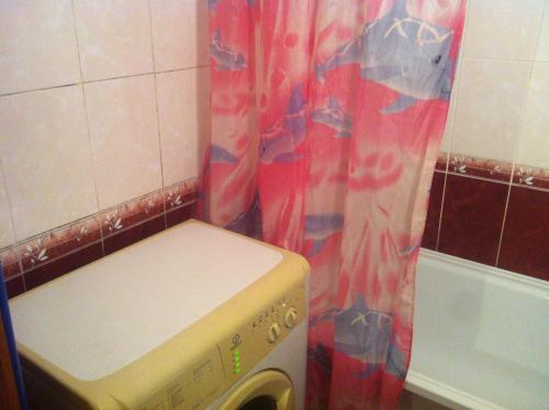 クストヴォにあるApartment on Zelenaya Street 18のバスルーム(シャワーカーテン付)の洗濯機が備わります。