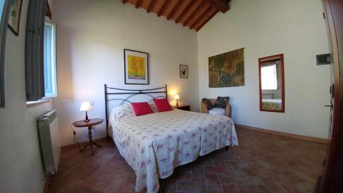 um quarto com uma cama com almofadas vermelhas em Podere Sant'Angelo em Roccalbegna