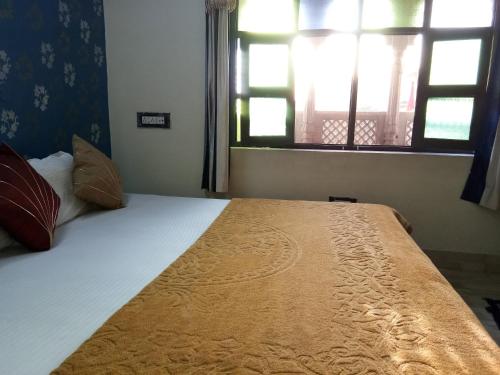 a large bed in a room with two windows at Haveli Taragarh Palace in Būndi