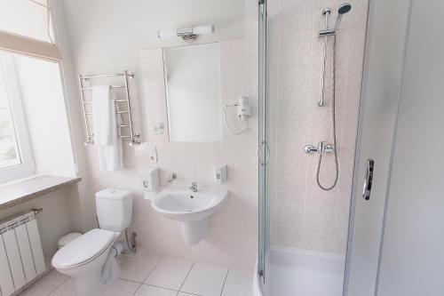 a bathroom with a toilet and a sink and a shower at VitaPark Borysfen in Kyiv