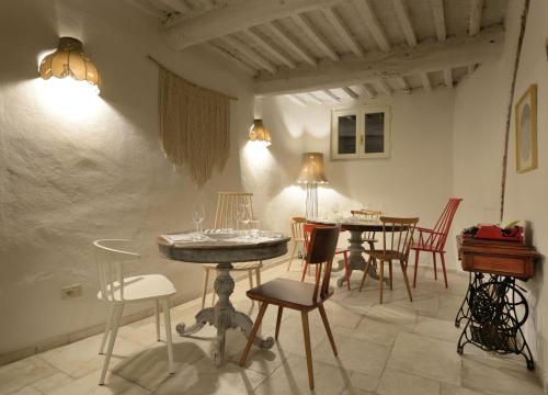 una sala da pranzo con tavoli, sedie e luci di Le camere di Sementis a Pietrasanta