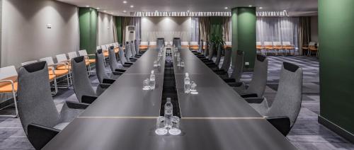 a long table in a room with chairs and wine glasses at Almaty Hotel in Almaty