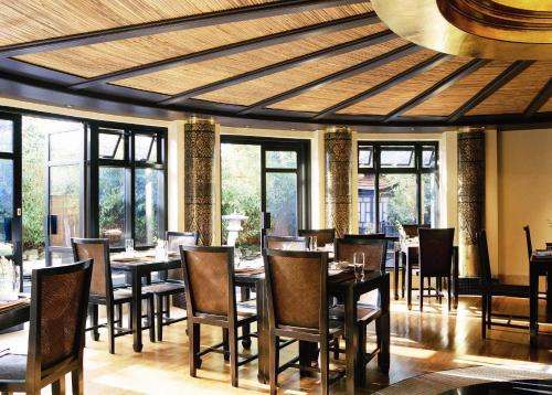 a dining room with tables and chairs and windows at Careys Manor Hotel & SenSpa in Brockenhurst