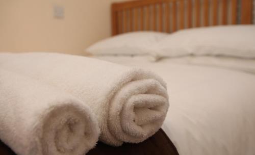 a white towel on the side of a bed at Castleyards Apartment 1 in Kirkwall