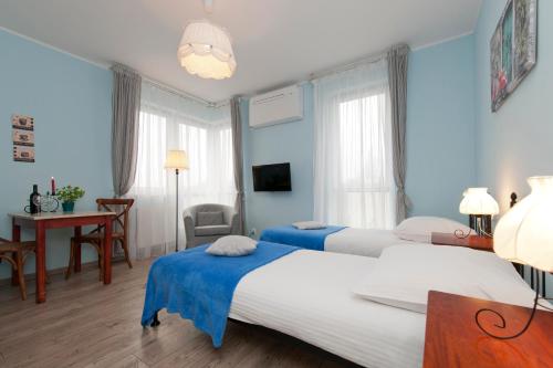 2 łóżka w sypialni z niebieskimi ścianami i biurkiem w obiekcie Apartamenty Marina House w Bydgoszczy