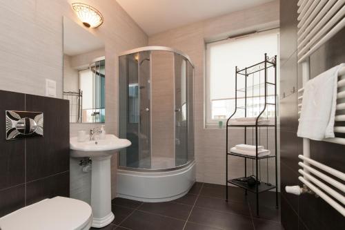 a bathroom with a shower toilet and a sink at Apartamenty Marina House in Bydgoszcz
