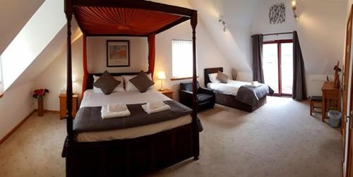 a bedroom with a four poster bed and a couch at Letterfinlay Lodge House in Letterfinlay