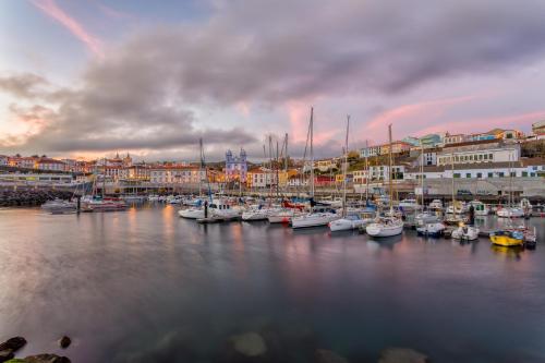a group of boats docked in a harbor with buildings at Casa de Hospedes Isaias in Angra do Heroísmo