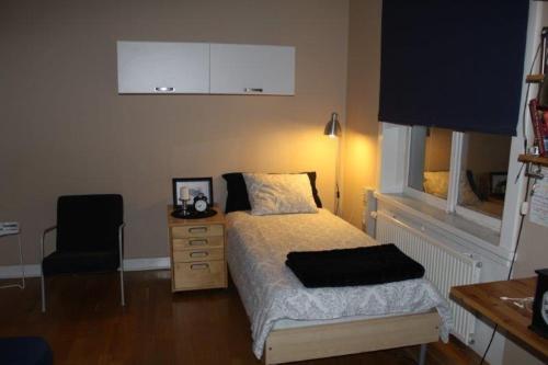 1 dormitorio con cama, escritorio y silla en Östra Flygeln Bunge Vandrarhem en Fårösund