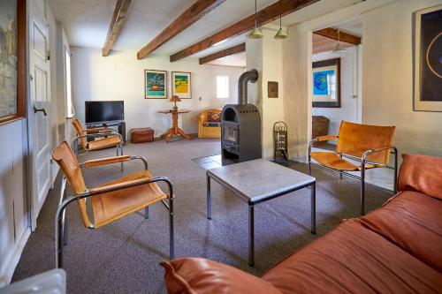 a living room with a couch and chairs and a stove at Møllegade 1 Holiday House in Nordborg