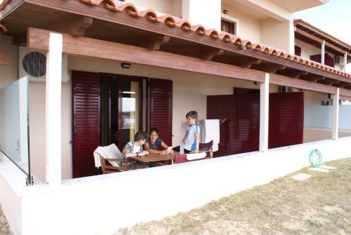 two people sitting at a table on the porch of a house at Ammos Residence in Minia