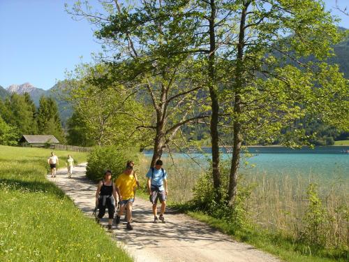 a group of people walking down a path next to a lake at Landhäusl in Weissensee
