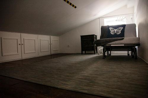 a room with a chair with a butterfly pillow on it at Villa Marquês near Tejo River in Cruz Quebrada