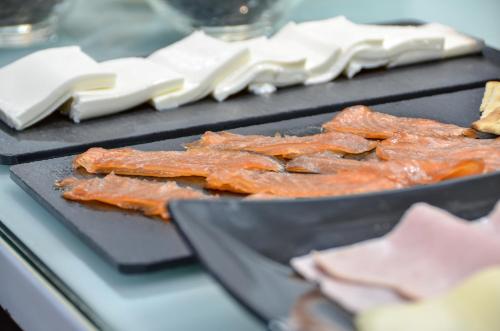 two pans of food on a table with meat at Hotel Miau in Madrid