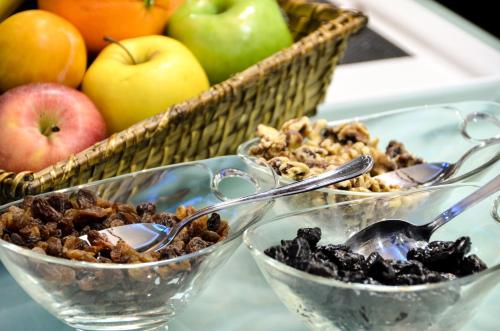 three bowls of nuts and apples and a basket of fruit at Hotel Miau in Madrid