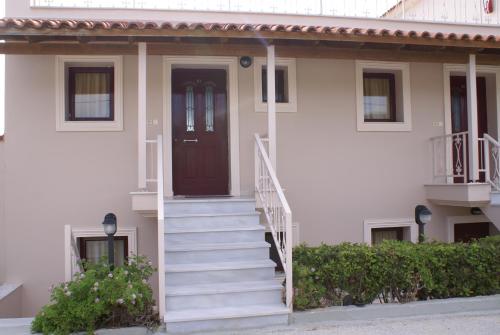 a white house with a staircase leading to a door at Ammos Residence in Minia
