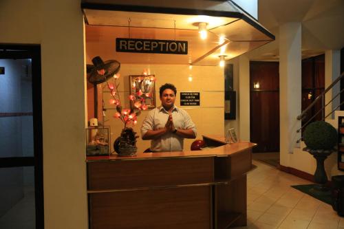 a man standing behind a counter in a restaurant at Hotel Nelly Vavuniya in Vavuniya