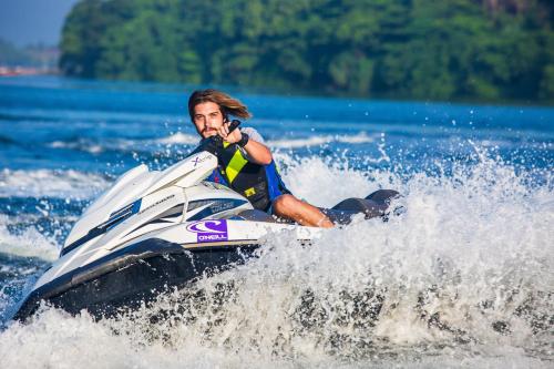 a man riding on a jet ski in the water at Villa Royal Apartments in Tivat