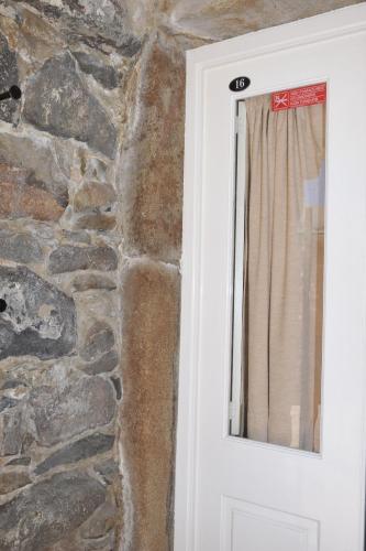 a white door with a stone wall at 16 Porto Santo Apartments in Porto Santo
