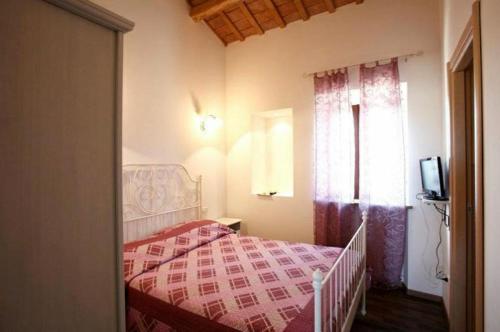 a bedroom with a bed with a red blanket and a window at Conero Ranch in Porto Recanati