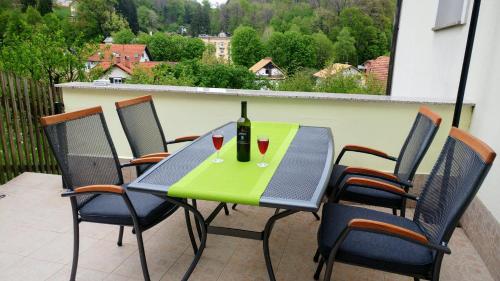 a table with a bottle of wine on a balcony at Apartments Ina in Rogaška Slatina