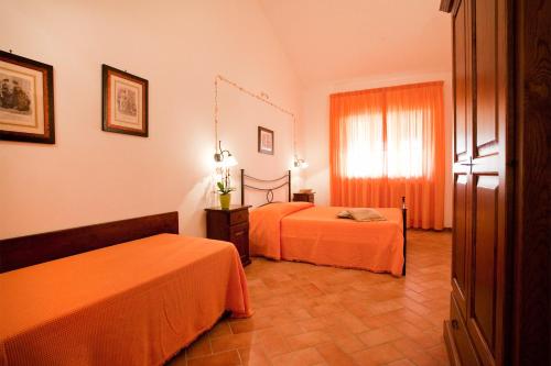 マリアーノ・イン・トスカーナにあるAgriturismo Vigna Maiのベッド2台と窓が備わるホテルルームです。