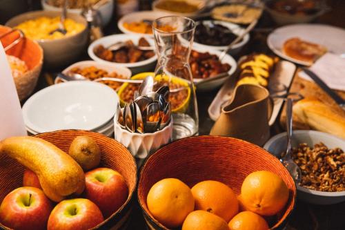 Hôtel Du Cloître في آرل: طاولة مليئة بأواني الفاكهة والأطعمة الأخرى