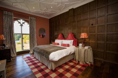 a bedroom with a large bed with red pillows at The North Wing - Combermere Abbey in Whitchurch
