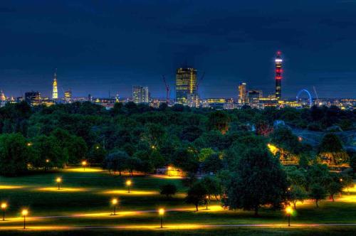 a park with a city skyline at night at The Studio - Heart Of Primrose Hill in London