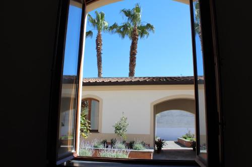 a view of a house through a window with palm trees at Pompei Hostel Deluxe in Pompei