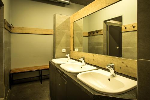 a bathroom with two sinks and a large mirror at Lakeside Paradise Sport Hostel in Knokke-Heist