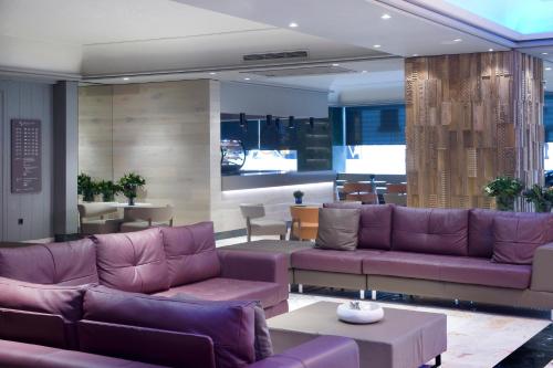 a living room with purple couches and a table at Sallés Hotel Pere IV in Barcelona