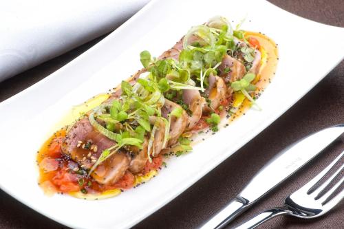 a plate of food with meat and salad on a table at Sallés Hotel Pere IV in Barcelona