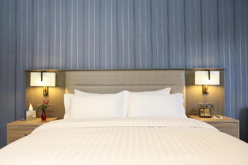 a bedroom with a large white bed with two night stands at Pendley Manor in Tring