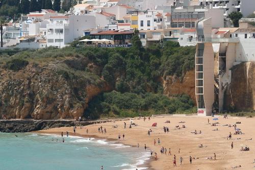 a group of people on a beach with buildings at Original 3 Bedroom Downtown in Albufeira