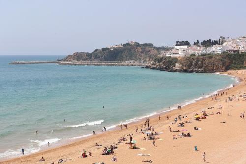 a group of people on a beach near the ocean at Original 3 Bedroom Downtown in Albufeira