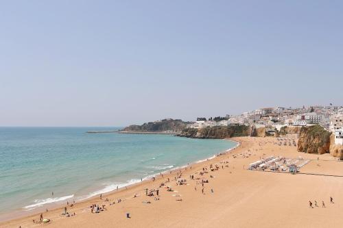 a group of people on a beach with the ocean at Original 3 Bedroom Downtown in Albufeira
