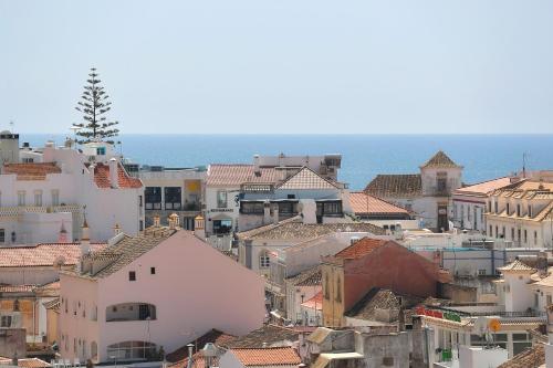 a view of a city with buildings and the ocean at Original 3 Bedroom Downtown in Albufeira