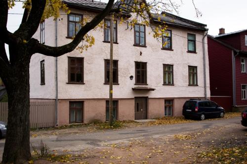 a white house with a car parked in front of it at Salme Apartment in Tartu