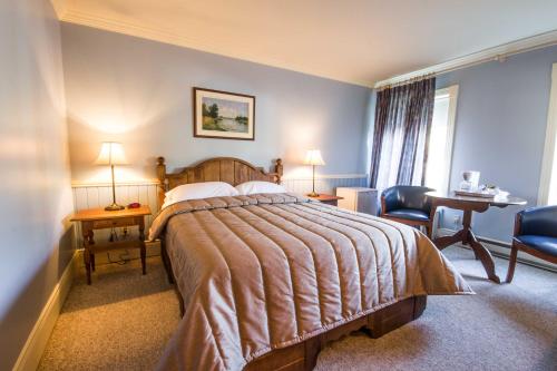 a hotel room with a bed and a desk at La Remontée Appartements Hôtel in La Malbaie